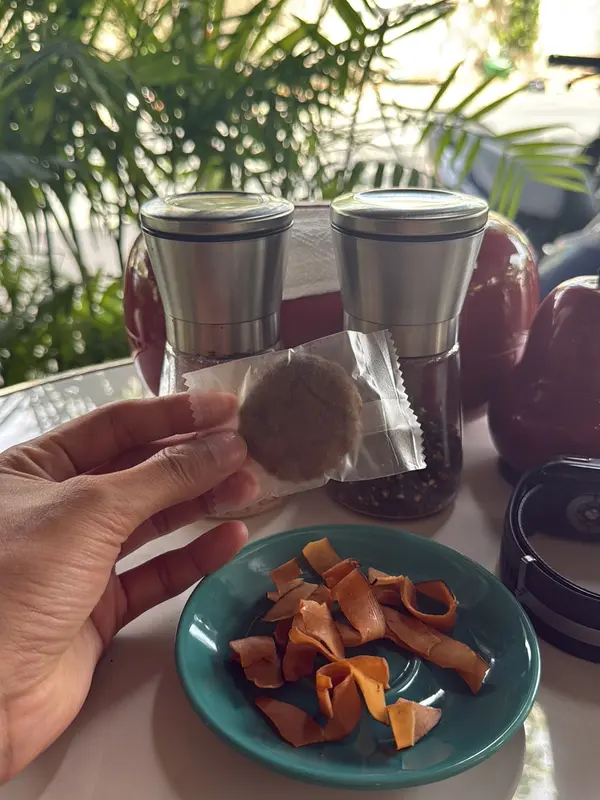 A guest holding a cookie beside a dish of coconut chips